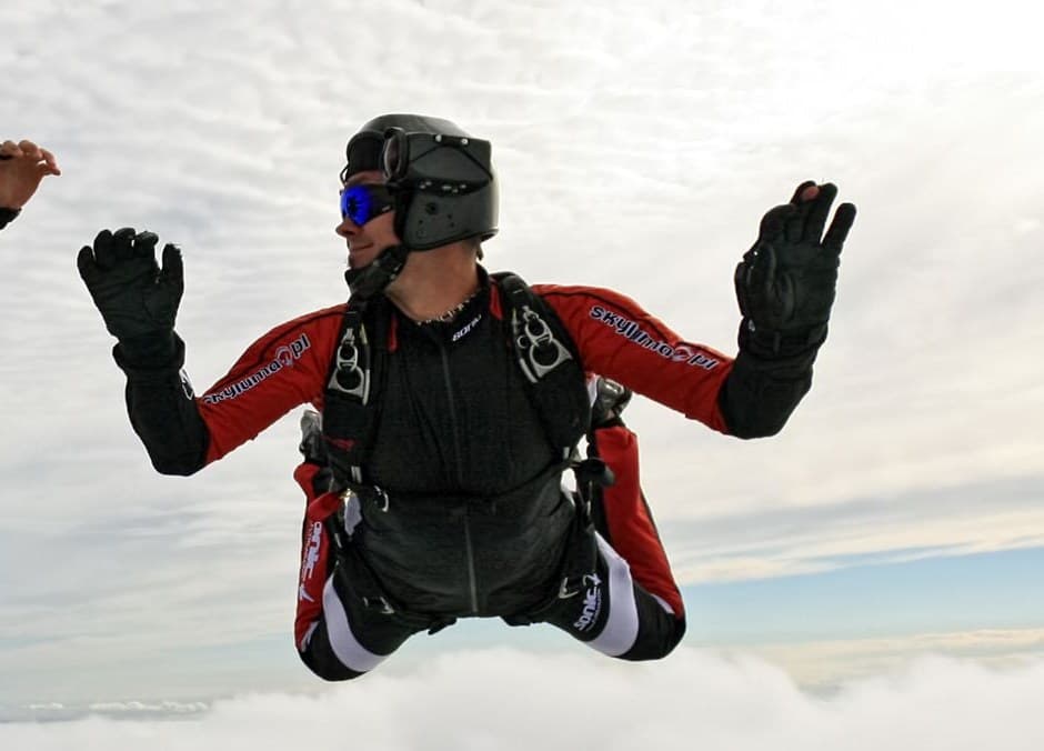 A jumper flying solo in freefall above a sea of clouds — what the course teaches