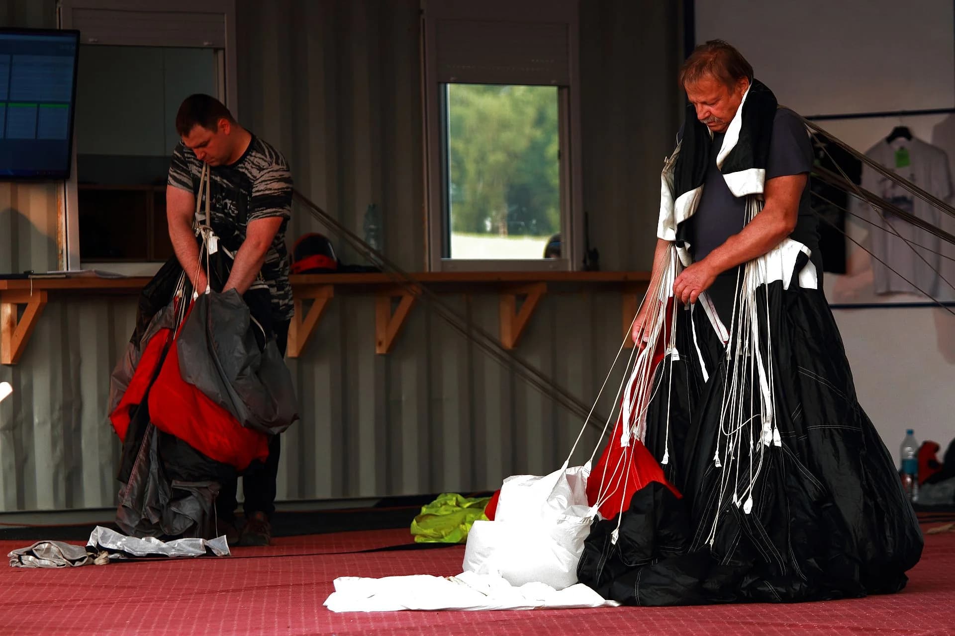 Parachutes being packed on tables in the hangar