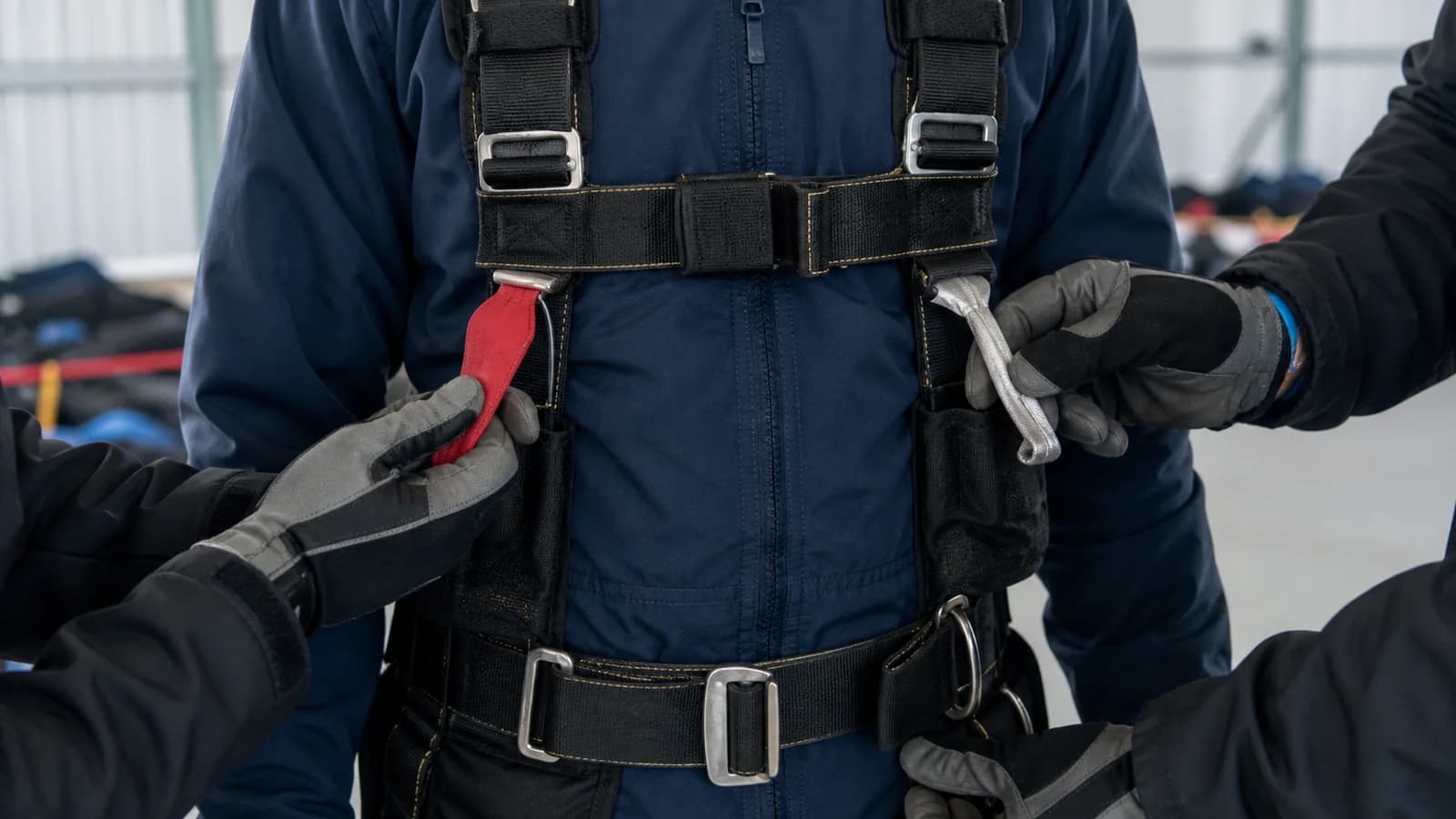 Instructors compare red and silver handles on a student harness